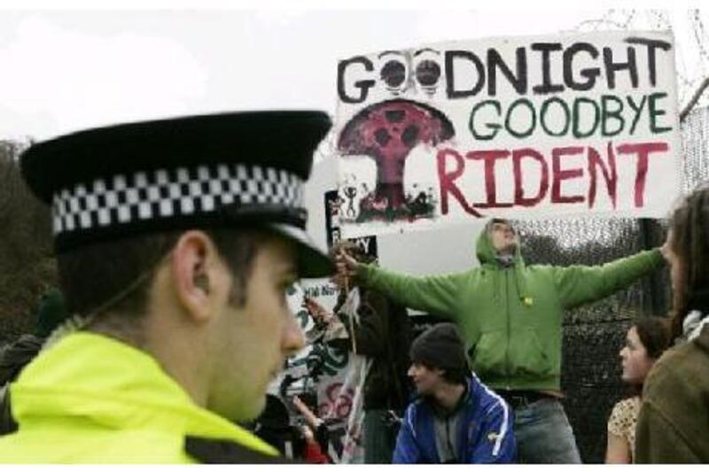 Protesters hold banners up during an anti-Trident missile replacement demonstration at the Faslane Naval base near Glasgow, Scotland.