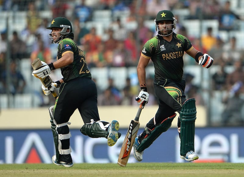 Pakistan batsmans Kamran Akmal (L) and Umar Akmal run between the wickets during the ICC World Twenty20 tournament cricket match between Australia and Pakistan at The Sher-e-Bangla National Cricket Stadium in Dhaka on March 23, 2014.��  AFP PHOTO/ PUNIT PARANJPE (Photo by PUNIT PARANJPE / AFP)