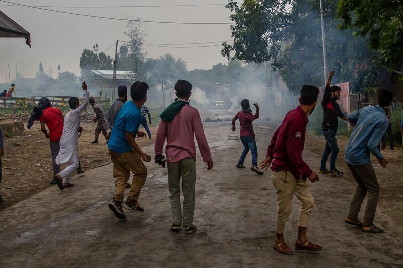 Kashmiri villagers throw stones and bricks amid tear gas smoke during a protest after the funeral procession of Akeel Ahmed Bhat, a teenage boy in Haal village, about 47 Kilometres (29 miles) south of Srinagar, Indian controlled Kashmir, Wednesday, Aug. 2, 2017. A fresh strike called by anti-India separatists to protest the killings of two top rebels and a civilian shut down disputed Kashmir Wednesday while a teenage boy died a day after he was wounded by government forces. (AP Photo/Dar Yasin)