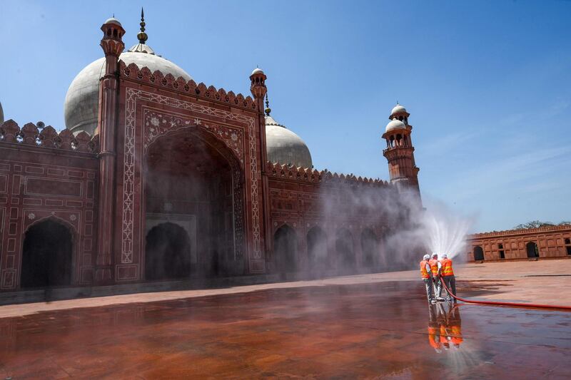 Municipal workers spray disinfectant at the main entrance of the Badshahi mosque ahead of the Muslim holy month of Ramadan during a government-imposed nationwide lockdown as a preventive measure against the COVID-19 coronavirus, in Lahore on April 22, 2020.
  / AFP / ARIF ALI
