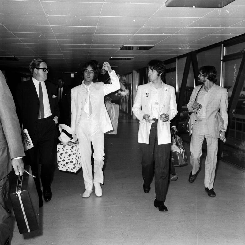 John Lennon and Paul McCartney, of The Beatles, arriving at London Airport, 16th May 1968. They are both dressed in white and carrying apples to promote their new company Apple Corps. (Photo by George Stroud/Express/Getty Images)