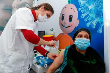 A healthcare worker administers a Covid-19 vaccine to a woman in Tel Aviv, Israel, on January 3, 2021. AFP