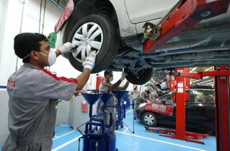 Toyota employees work on cars at a service station in Dubai.