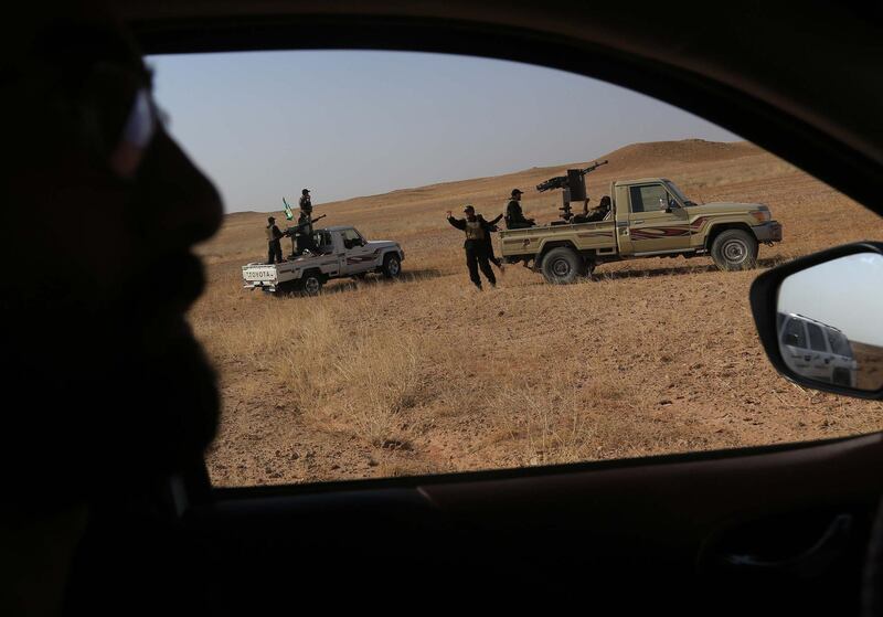 Forces of Iraq's Hashed Al Shaabi (Popular Mobilisiation) paramilitaries stand in the back of pickup trucks during a military operation in the desert area between Karbala and Anbar.  AFP