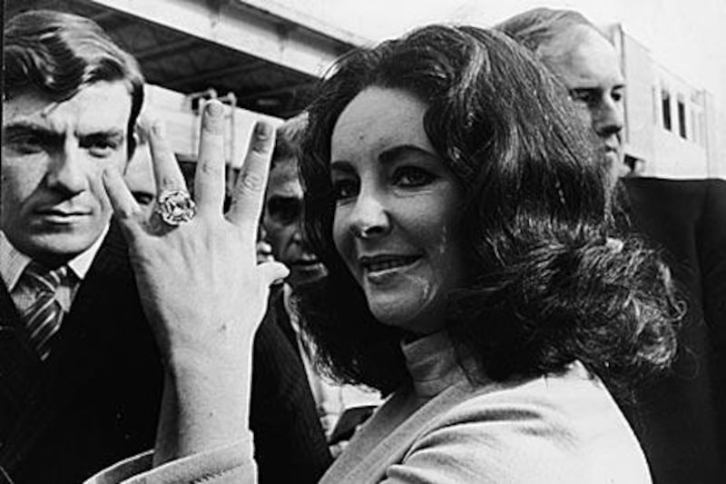 Elizabeth Taylor shows off a 33.19 carat diamond ring given to her in 1968 by her then-husband Richard Burton.