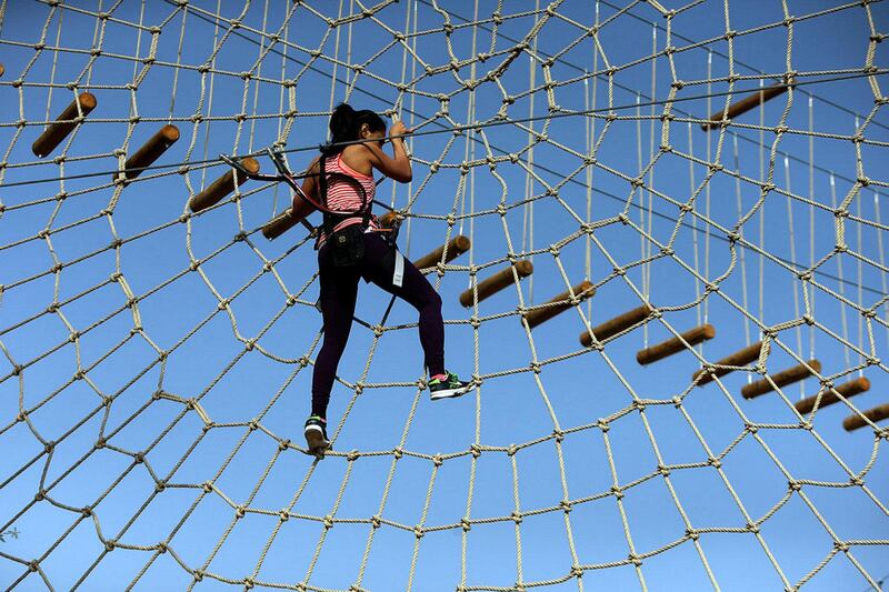 Dubai resident tests out the rope and zipline obstacles at the Aventura nature adventure park, as Mushrif Park in Dubai. Satish Kumar / The National