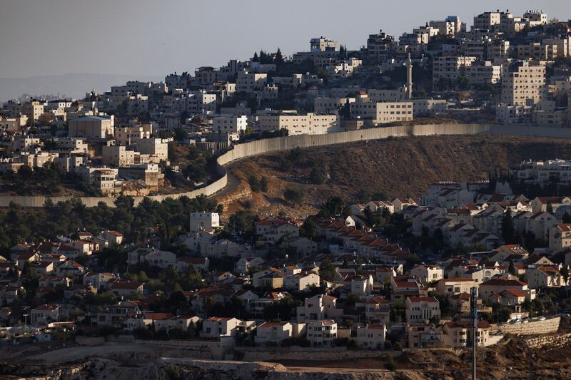A wall divides the Palestinian West Bank territory, top, from an illegal Israeli settlement below, in Al Ram, the occupied West Bank. Getty Images