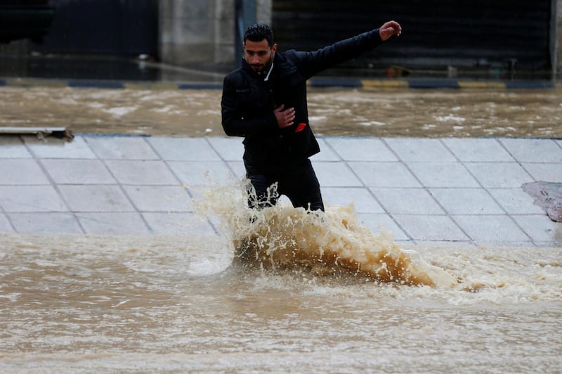A man crosses a flooded street in Amman. Reuters