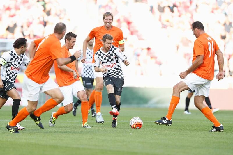 Sebastian Vettel (white jersey) challenges for the ball with Sebastian Kehl (L) and Dirk Nowitzki (behind) during the ‘Champions for Charity’ football match between Nowitzki All Stars and Nazionale Piloti in honour of Michael Schumacher at Opel Arena on July 27, 2016 in Mainz, Germany. Andreas Rentz / Getty Images