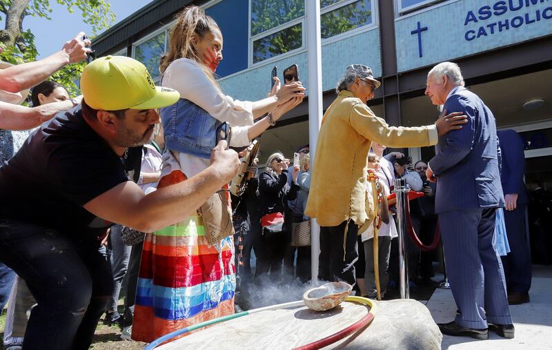 People react as Britain's Prince Charles speaks with indigenous drummer, Okimajd Anderson, during a visit to Assumption Elementary School, on the second day of the Canadian 2022 Royal Tour, in Vanier, Ottawa. Reuters