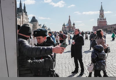 A police officer searches a man at the entrance to the Red Square. EPA