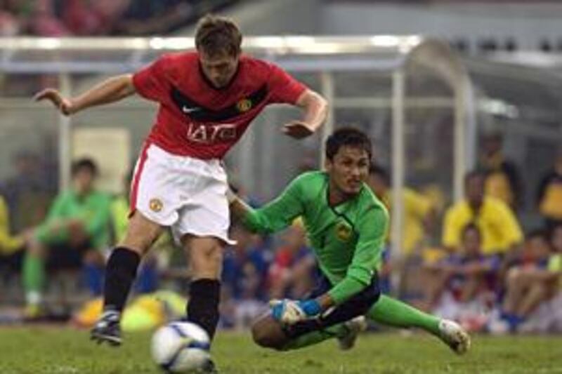 New signing Michael Owen beats goalkeeper Mohd Farizal Marlias to score the winning goal for Manchester United against a Malaysian X1 in Kuala Lumpur on Saturday.