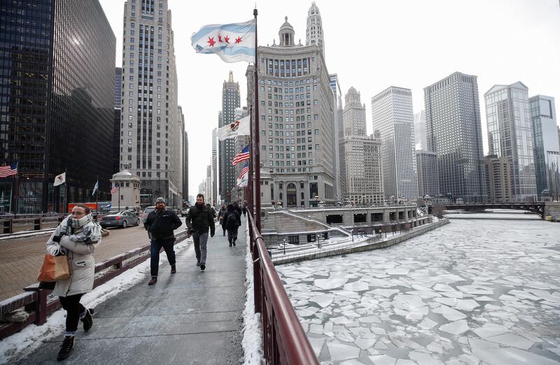 Pedestrians walk along Michigan Avenue above the frozen Chicago River in Chicago. EPA