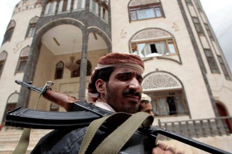 Armed guards stand at the entrance of the house of Yemeni tribal leader Sadiq al-Ahmar in Sanaa May 26, 2011.Dozens of Yemenis were killed in overnight gun battles in the capital, government officials said on Thursday, as fighting aimed at ending President Ali Abdullah Saleh's three-decade-long rule threatened to ignite civil war. Yemen's state prosecutor ordered the arrest of "rebellious" leaders of the tribal group led by the al-Ahmar family and a government official said the headquarters of an opposition television station had been "destroyed", without giving details.              REUTERS/Ammar Awad (YEMEN - Tags: POLITICS CIVIL UNREST) *** Local Caption ***  AWA08_YEMEN-_0526_11.JPG