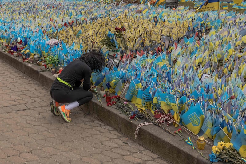 A woman reacts next to flags bearing symbols and colours of Ukraine set to commemorate fallen Ukrainian army soldiers at Independence Square in Kyiv. AFP