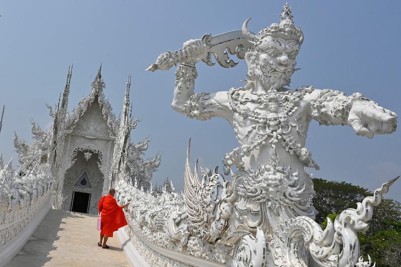 A Buddhist monk ascends the steps to visit the Wat Rong Khun, or White Temple, in Chiang Rai province, northern Thailand. AFP