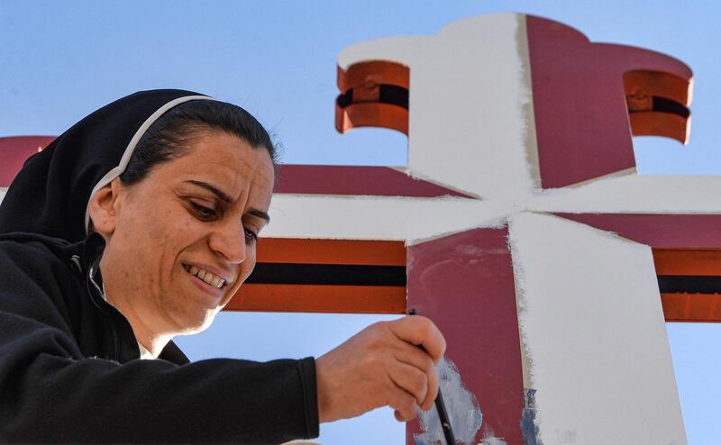 A nun adds a coat of paint to the crucifix at the Immaculate Mary Convent in Qaraqosh, in preparation for the visit of Pope Francis in March. AFP
