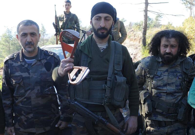 Alpaslan Celik, a deputy commander in a Syrian Turkmen brigade, centre, holding what is believed to be parts of a parachute used by a Russian pilot who ejected from a downed military jet near the northern Syrian village of Yamadi, near the Turkish-Syrian border, Syria on November 24, 2015. Reuters