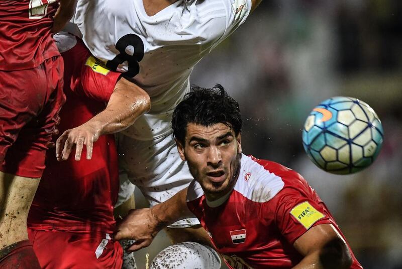 Khaled Almbayed of Syria, right, heads the ball against Morteza Pouraliganji of Iran, second left, during the 2018 World Cup qualifying football match between Syria and Iran at Tuanku Abdul Rahman Stadium in Seremban. AFP