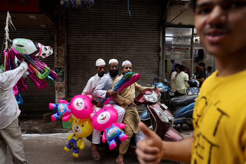 Men carry party balloons in the old quarters of Delhi. Reuters