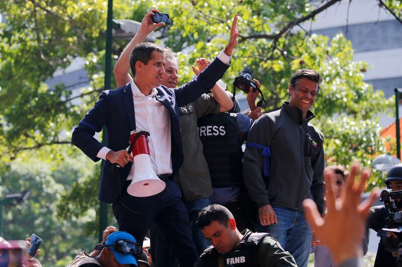 Mr. Guaido, holding megaphone, and opposition leader Leopoldo Lopez, top right, stand before supporters in Altamira Plaza. AP Photo