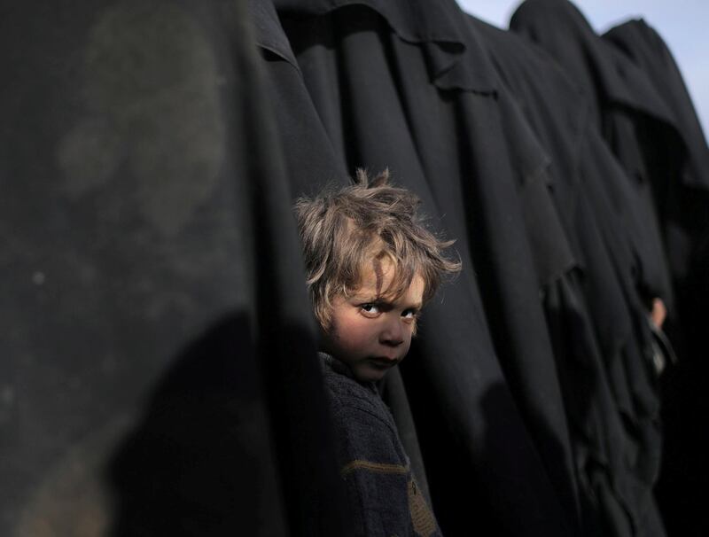 A boy looks at the camera near Baghouz, Deir Al Zor province, Syria. Reuters