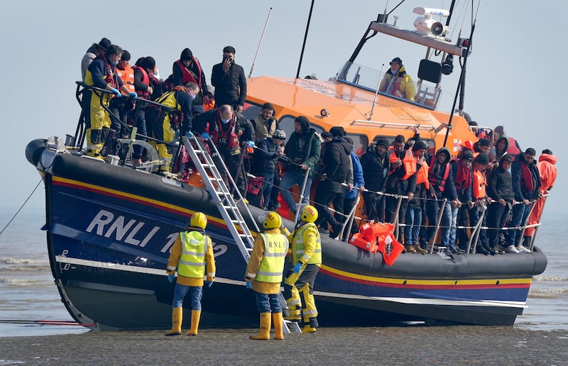 A group of people thought to be migrants are brought in to Dungeness, Kent, on board the RNLI Lifeboat following a small boat incident in the Channel. PA