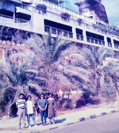 Rita Pradeep Nair (in blue jeans and t-shirt) with colleagues against the backdrop of a bombed Kuwaiti naval frigate. Courtesy Rita Pradeep Nair