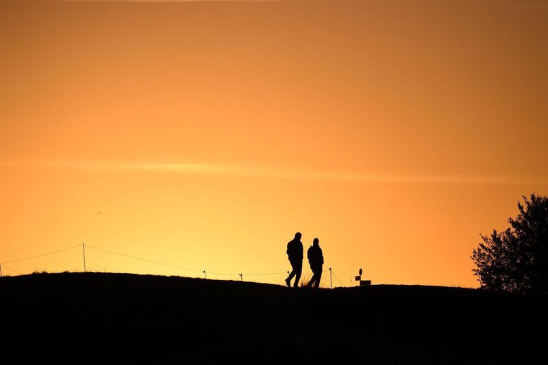 Men walk on a fairway at sunrise ahead of the 42nd Ryder Cup at Le Golf National Course at Saint-Quentin-en-Yvelines, south-west of Paris.  Franck Fife / AFP