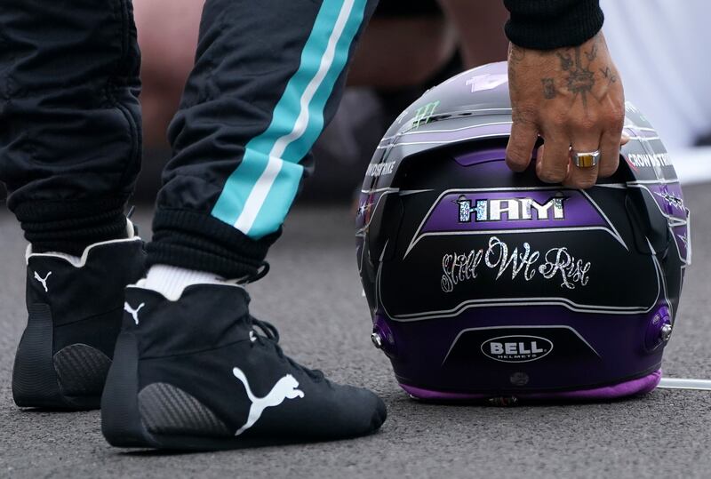 Mercedes driver Lewis Hamilton of Britain sets his helmet.