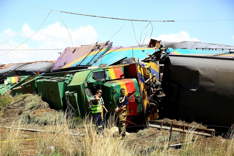 Workers stand next to a wreckage after a train crash near Hennenman in the Free State province, South Africa, January 4, 2018. REUTERS/Stringer