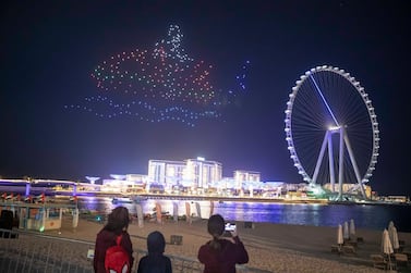 Visitors watch one of the nightly drone shows in Dubai to celebrate the shopping festival. Antonie Robertson / The National