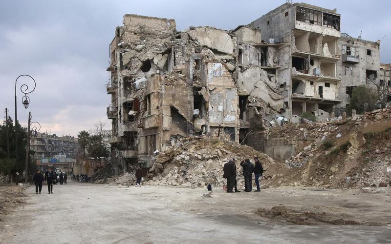 Syrians walk along a destroyed street in the old city of Aleppo. Youssef Karwashan / AFP 

