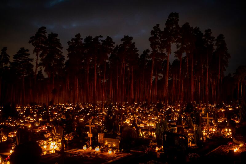 Candles are lit during All Saints Day at a cemetery in Vilnius, Lithuania. AP