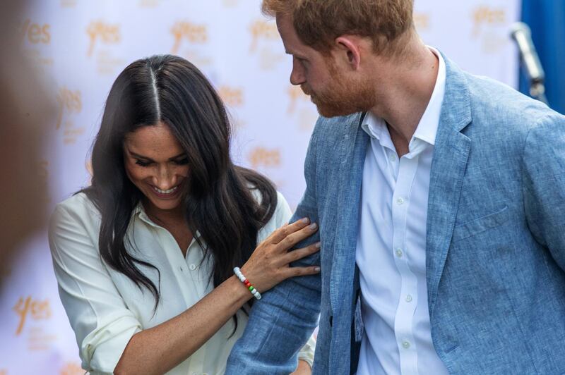 Britain's Prince Harry, Duke of Sussex(R) and Meghan, Duchess of Sussex(L) leave the Youth Employment Services Hub in Tembisa township, Johannesburg, on October 2, 2019. - Meghan Markle is suing Britain's Mail On Sunday newspaper over the publication of a private letter, her husband Prince Harry has said, warning they had been forced to take action against "relentless propaganda". (Photo by Michele Spatari / AFP)