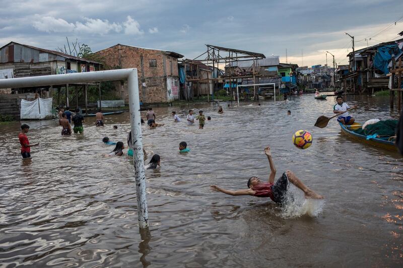 A boy attempts a bicycle kick in a flooded area of the Belen community in Iquitos, Peru. AP Photo