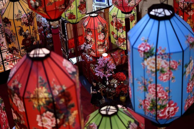 A shopper takes photographs of Chinese New Year lanterns at a shopping mall in Kuala Lumpur. Manan Vatsyayana / AFP Photo