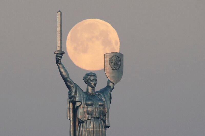 The pink supermoon sets behind the giant 'Mother of the Motherland' statue in central Kiev, Ukraine. Reuters