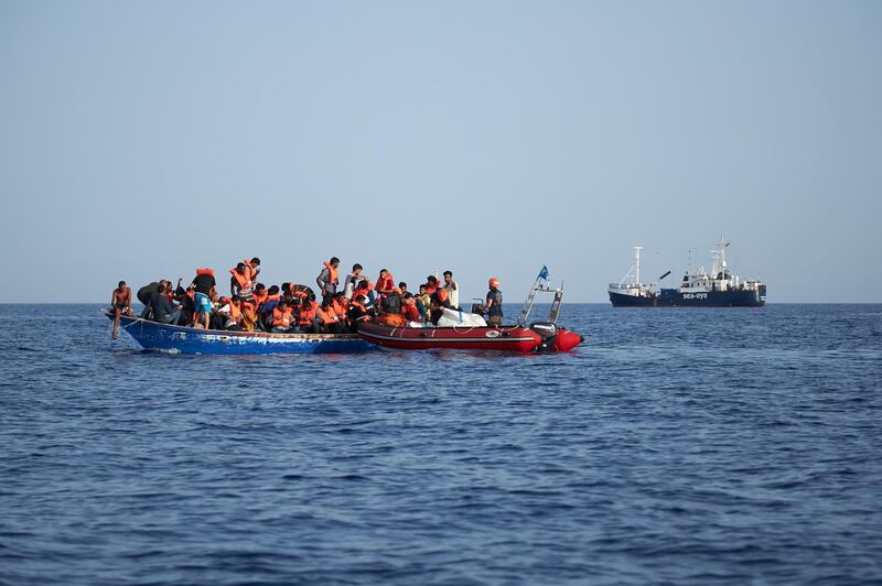 Migrants are transferred from their own boat to a rescue craft in the Mediterranean Sea between Malta and Lampedusa. EPA
