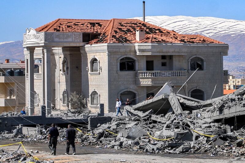 People walk past a building hit in an Israeli air strike in Baalbek, Lebanon on Monday night. AFP