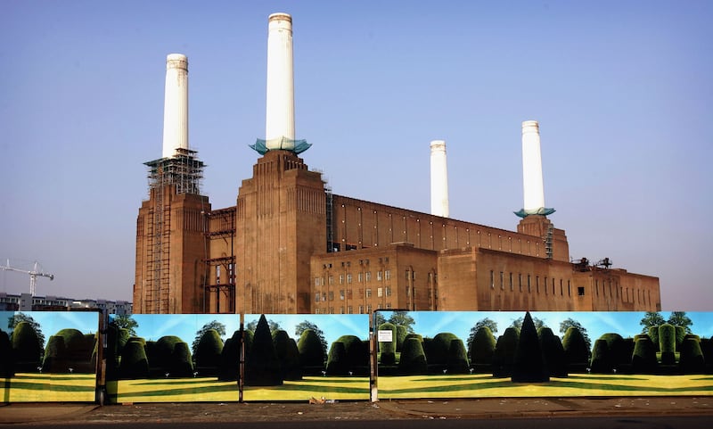 Battersea Power Station stands behind boards painted with a landscape in 2005. Getty Images
