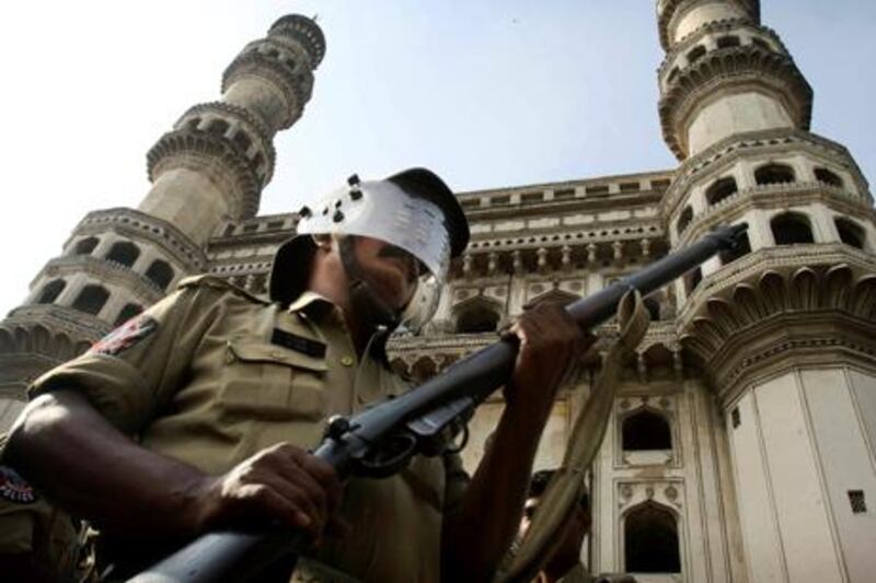An Indian policeman stands guard in front of the landmark Charminar, ahead of a potentially explosive court verdict on whether Hindus or Muslims should control a disputed holy site in Ayodhya, in Hyderabad, India, Thursday, Sept. 30, 2010. Police have arrested more than 10,000 people to prevent them from inciting violence, while another 100,000 had to sign affidavits saying they would not cause trouble after the verdict, a top official said. A 16th-century Babri Mosque, Hindus claim was erected at the birthplace of their god Rama, stood at the disputed site in the town of Ayodhya before it was razed by Hindu hard-liners in 1992, setting off violence that killed 2,000 nationwide. (AP Photo/Mahesh Kumar A.)