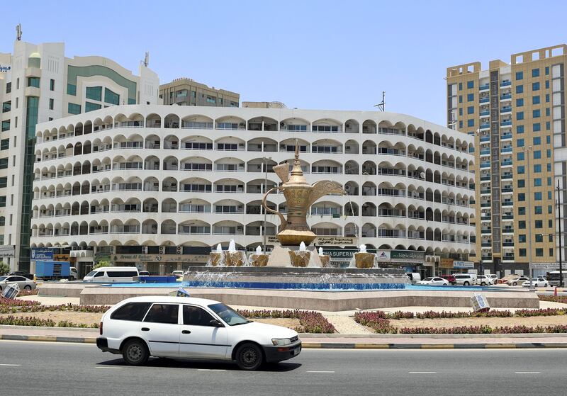 A roundabout in Fujairah with a giant dallah or Arab coffee pot surrounded by fountain 'coffee cups'.