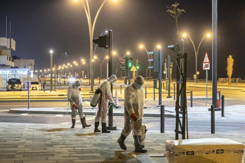 SHARJAH, UNITED ARAB EMIRATES. 26 MARCH 2020. Sharjah Municipal staff spray and disinfect the sidewalk along the Al Muntazah Str area of Sharjah near the Ajman border. (Photo: Antonie Robertson/The National) Journalist: None. Section: National.
