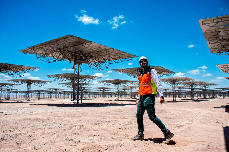 A worker walks near solar panels at Cerro Dominador, the first thermosolar power plant in Latin America, in Antofagasta, Chile, on February 26, 2019. Cerro Dominador is the symbol of the ambitious energetic transition launched by Chile, which aims at having 100% of its energy matrix clean for 2040.
 / AFP / Martin BERNETTI
