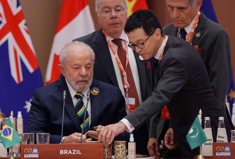 Brazil's President Luiz Inacio Lula da Silva speaks with his advisors before the start of the second working session. AFP