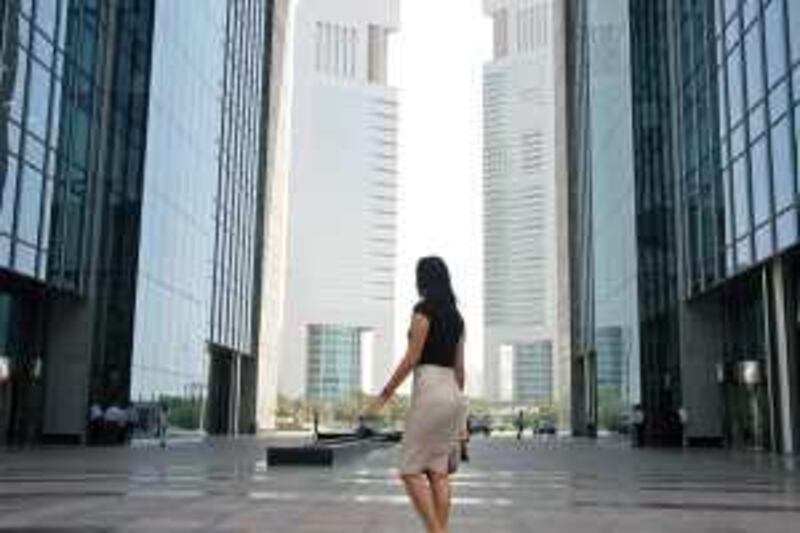 DUBAI, UNITED ARAB EMIRATES - JUNE 23:  A woman walks by The Gate at the Dubai International Financial Centre (DIFC), in Dubai, on June 23, 2009.  The Emirates Towers can also be seen.  (Randi Sokoloff / The National)  For stock *** Local Caption ***  RS003-062309-DIFC-STOCK.jpgRS003-062309-DIFC-STOCK.jpg