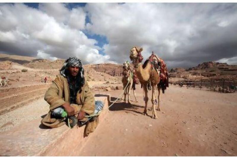 A camel owner in south Jordan waits for tourists to come for a riding tour to Petra, where tourism is down due to regional instability.