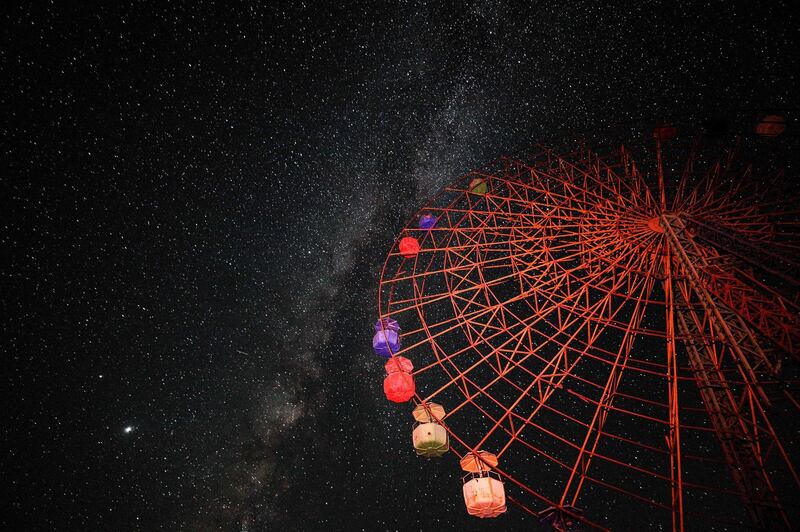 This long-exposure picture taken shows a view of the Milky Way rising in the sky behind a Ferris Wheel above an abandoned children's amusement park near Al Nayrab, a village ravaged by pro-government forces bombardment, in Syria's northwestern Idlib province.  AFP