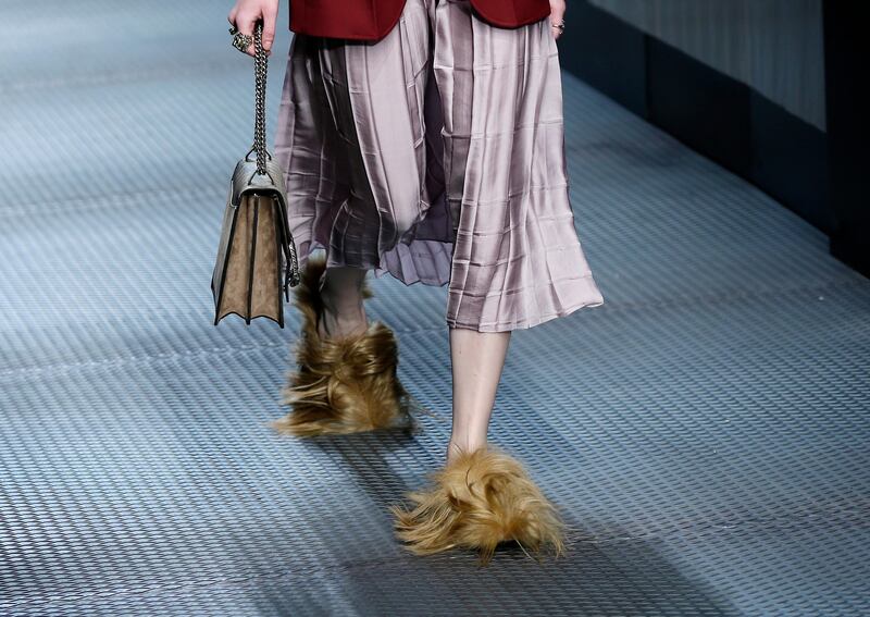 FILE - In this Wednesday, Jan. 25, 2015 file photo, a model wears footwear with wisps of fur as part of the Gucci women's Fall-Winter 2015-2016 collection, in Milan, Italy. Gucci has become the latest fashion house to eliminate animal fur from its collections, starting with the spring-summer 2018 season. The Humane Society, which supports the fur free alliance among fashion houses, said Gucci��������s announcement Wednesday was a ���������������game-changer,���������������� involving   ���������������perhaps the biggest fur-free retailer announcement worldwide to date.���������������� Gucci CEO Marco Bizzarri  said the brand would no longer ���������������use, promote or publicize animal fur,���������������� beginning with the menswear collection to be previewed in January and womenswear in February. Gucci said it would auction off the remaining fur animal items, with proceeds to benefit LAV and the Humane Society. (AP Photo/Antonio Calanni, File)